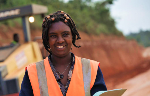 Photo d'une femme sur chantier extérieur avec veste fluorescente de sécurité.